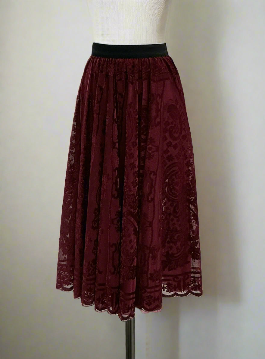 Maroon lace skirt on a mannequin in a clothing store setting